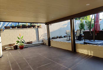 Elegant tile installation under patio cover with outdoor furniture in Sylmar home.